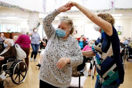 Residents and staff gather during an Easter concert for vaccinated residents at the Ararat Nursing Facility on April 1, 2021 in Los Angeles.  The concert was the first social event at the facility since the beginning of the pandemic.