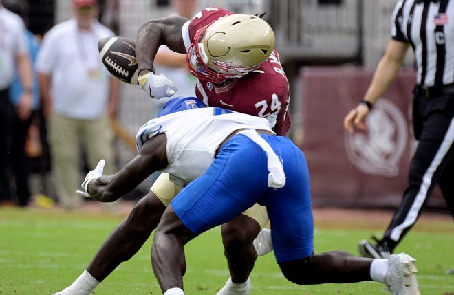 Memphis defensive back An'Darius Coffey (4) forces a fumble by Florida State running back Roydell Williams (24) during the first half at Doak S. Campbell Stadium.