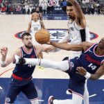 Los Angeles Clippers guard Terance Mann, right, shoots as San Antonio Spurs center Victor Wembanyama, top, defends and center Ivica Zubac watches during the first half of an NBA basketball game, Monday, Nov. 4, 2024, in Inglewood, Calif. (AP Photo/Mark J. Terrill)